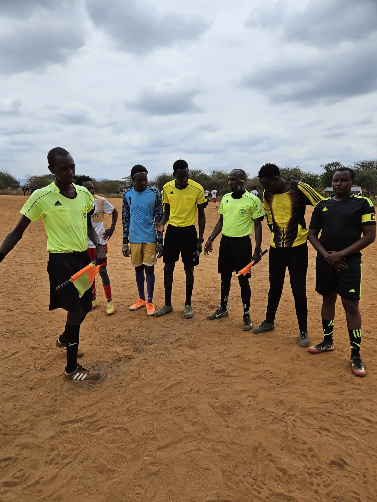 Tournament officials and players at the Maparasha football field